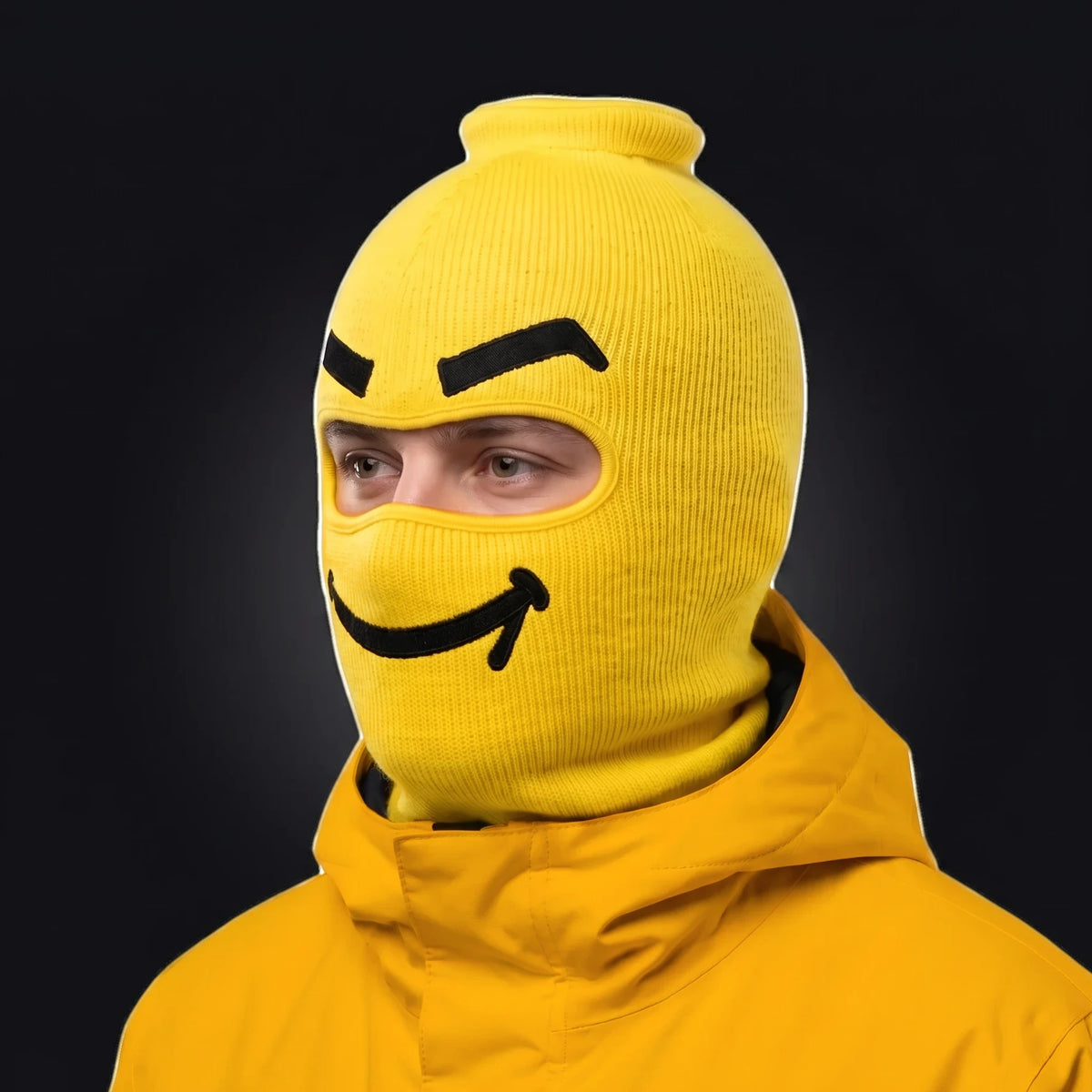 Three-quarter view of the Smuggles ski mask pulled over the head, ears and neck, worn with a Goon Yellow jacket.